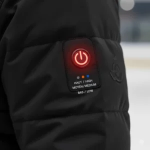 Close-up of a heated jacket power button with three heat settings, ideal for staying warm in cold Canadian rinks or arénas de hockey.