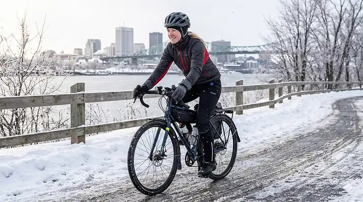 A cyclist commuting through a snowy Canadian city wearing battery-operated heated pants for winter cycling.